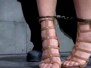 Slave mask sub has her arms chained up. Slave mask sub has her arms chained up to await her punishment